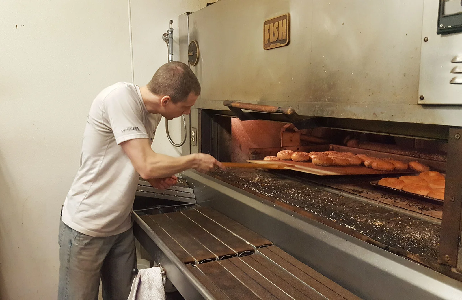 A Bagel Bistro baker working at the oven